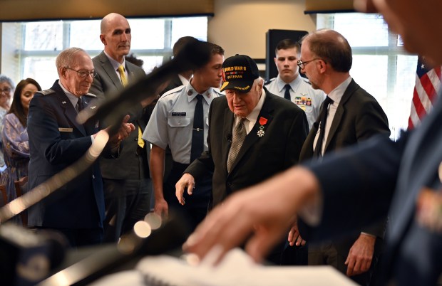 Center left to right, World War II veteran Emil G. Hirsch, 98, of Northbrook, has been awarded France's highest distinction, the French Legion of Honor, by (right) Yannick Tagand, consul general of France in Chicago, and is approaching the podium to speak on April 5, 2024 in Northbrook at Brookdale Senior Living Solutions (4501 Concord Lane). (Karie Angell Luc/for the Pioneer Press)