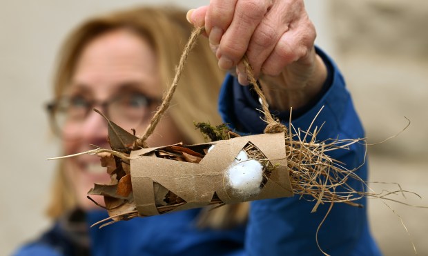 Meridith Clement of Glencoe holds up a bird nest buffet tube for birds to find to use in nest building. Clement is a board trustee with the Friends of the Green Bay Trail. Taken at the Earth Day Clean-Up event at Glencoe Beach on April 20, 2024 in Glencoe. (Karie Angell Luc/Pioneer Press)