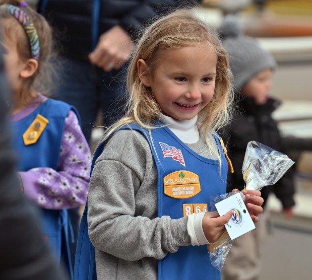 Summer Mygatt, 5, a kindergartner from Glencoe, with Glencoe Daisy Girl Scout Troop 47866, is happy with her badge and cookie at the Earth Day Clean-Up event at Glencoe Beach on April 20, 2024 in Glencoe. (Karie Angell Luc/Pioneer Press)