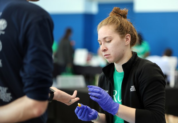 Rush university student Lauren Blacker performs a health check on an attendee of the Oak Park and River Forest Chamber of Commerce health and wellness fair held April 21, 2024 at the Community Recreation Center in Oak Park. (James C. Svehla/Pioneer Press)