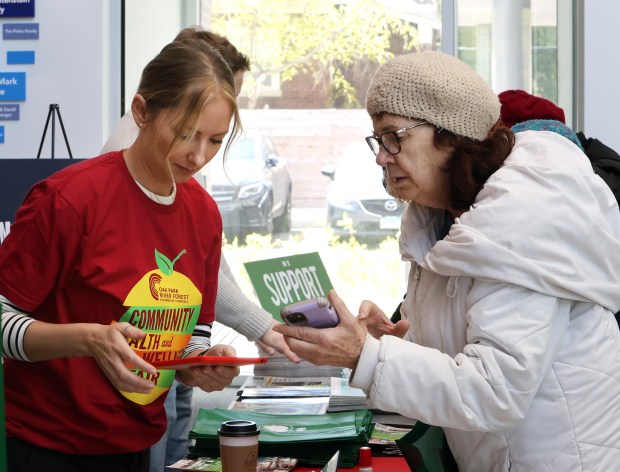 Shana Taveras checks in Lyn Dupee during the The Oak Park and River Forest Chamber of Commerce health and wellness fair held April 21, 2024 at the Community Recreation Center Sunday in Oak Park. (James C. Svehla/ Pioneer Press)