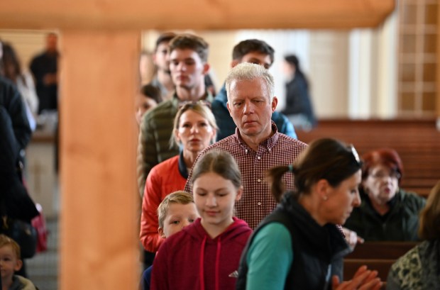 People approach the altar to the cross after the Stations of the Cross at Our Lady of Perpetual Help Church in Glenview on Good Friday, March 29, 2024. (Karie Angell Luc/for the Pioneer Press)