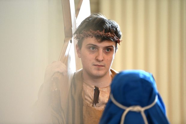 As Jesus, Thomas Jachtorowycz, 17, a Glenbrook South High School junior from Glenview, walks the Stations of the Cross at Our Lady of Perpetual Help Church in Glenview on Good Friday, March 29, 2024. In blue is Mary, the Blessed Mother, Evie Philbrick, 11, a fifth-grader from Glenview. (Karie Angell Luc/for the Pioneer Press)