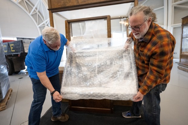 Mario Longoni, lead environmental social scientist with the Field Museum Keller Science Action Center, on right, assists South Shore CVA facility manager Jerry Tachik Jr. with the unwrapping of an exhibit in preparation for the upcoming "Calumet Voices, National Stories from the Field Museum" show at the Indiana Welcome Center on Friday, April 5, 2024. (Kyle Telechan/for the Post-Tribune)