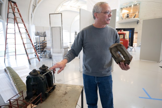 NWI Steel Heritage Project president Bob Meyer points to a model Hot Strip Mill, made in the 1930s by a steelworker, as he helps set up the "Calumet Voices, National Stories from the Field Museum" exhibit at the Indiana Welcome Center on Friday, April 5, 2024. (Kyle Telechan/for the Post-Tribune)