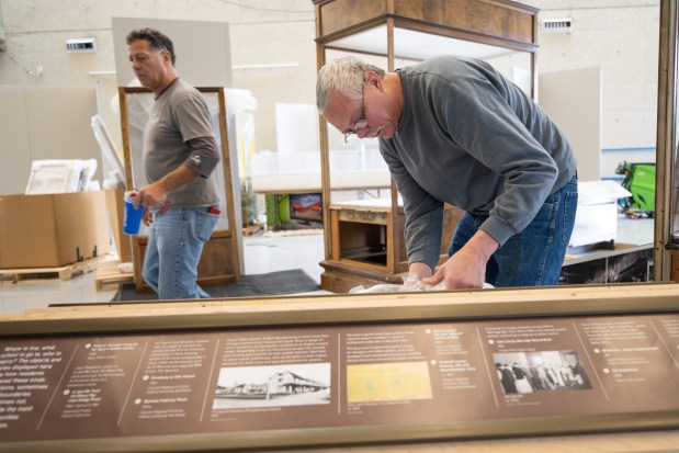 NWI Steel Heritage Project president Bob Meyer helps unwrap signage as the "Calumet Voices, National Stories from the Field Museum" exhibit is set up at the Indiana Welcome Center on Friday, April 5, 2024. (Kyle Telechan/for the Post-Tribune)