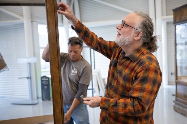 Mario Longoni, lead environmental social scientist with the Field Museum Keller Science Action Center, helps prep a display cabinet as the "Calumet Voices, National Stories from the Field Museum" exhibit is set up at the Indiana Welcome Center on Friday, April 5, 2024. (Kyle Telechan/for the Post-Tribune)