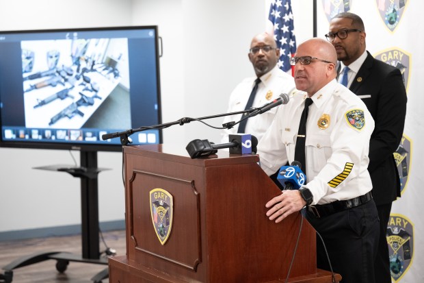 Gary Police Commander Jack Hamady speaks as an image of a weapons bust is shown on a screen nearby during a news conference at the Gary Police Department on Wednesday, April 3, 2024. (Kyle Telechan/for the Post-Tribune)