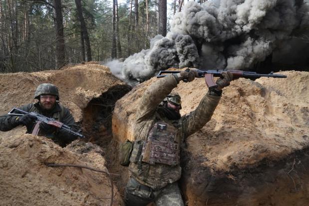 FILE - Ukrainian National guard soldiers simulate assault operations during tactical training at a shooting range in Kharkiv region, Ukraine, on Thursday, Feb. 29, 2024. Ukrainian President Volodymyr Zelenskyy ordered construction of new defensive lines, but experts note that the effort has dragged on too slowly, leaving critical areas unprotected. (AP Photo/Andrii Marienko, File)