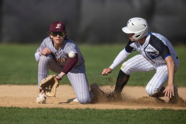 Lincoln-Way East's MJ Schley, pops up safely on a steal at second base as Lockport's Joey DalPonte waits for a ball during a South West Suburban Conference game in Frankfort on Thursday, April 25, 2024. (Vincent D. Johnson/for the Daily Southtown)