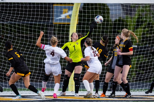 As she stumbles backwards, Lockport's Brinlee McNabb (4) watches the ball she just bodied go above Andrew's keeper Kadence Jones (1) for a goal during the second half of a South West Suburban Conference game in Tinley Park on Monday, April 2, 2024. (Vincent D. Johnson/for the Daily Southtown)