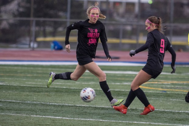 Lincoln-Way East's Kara Waishwell passes the ball off to Elizabeth Burfeind (9) against Lincoln-Way West during a South West Suburban Conference crossover game in Frankfort on Thursday, April 4, 2024. (Vincent D. Johnson/for the Daily Southtown)