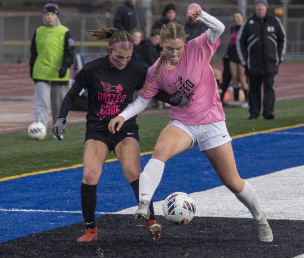 Lincoln-Way East's Elizabeth Burfeind, left, and Lincoln-Way West's Julia Urbanczyk battle for a ball during a South West Suburban Conference crossover game in Frankfort on Thursday, April 4, 2024. (Vincent D. Johnson/for the Daily Southtown)