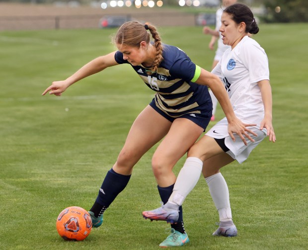 Lemont Casey Kittridge and Reavis Jasmine Juache battle for the ball during the soccer game in Lemont Thursday, April 18, 2024. (James C. Svehla/for the Daily Southtown)