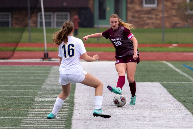 Lockport's Meghan Mack (26) kicks arounds Wheaton North's Casey Kenny (16) during the Lockport Invitational Championship in Lockport on Thursday, April 11, 2024. (Nate Swanson/for the Daily Southtown)