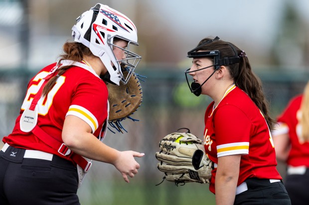 Mother McAuley's Chloe Jacklin, left, talks with her pitcher Elizabeth Wood during the Southside Showcase against Evergreen Park in Evergreen Park on Friday, April 12, 2024. (Vincent D. Johnson/for the Daily Southtown)