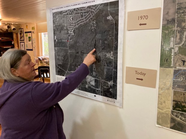 Judy Dolan Mendelson points out a line of evergreen trees on a 1970 aerial photo of Thorn Creek Woods in Park Forest on April 18, 2024 at Thorn Creek Nature Center. (Paul Eisenberg/Daily Southtown)