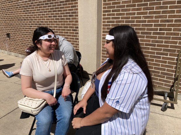 Guadalupe Rodziguez, left, and Juliassa Acosta watch the solar eclipse April 8, 2024 in the College Scholar's Garden at Prarie State College in Chicago Heights. (Alexandra Kukulka/Daily Southtown)