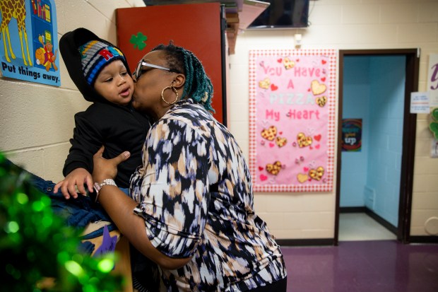 Joziah McAllister, 1, sits while Candice Coleman, director of the care center, gives him a goodbye kiss at the end of the school day on March 5, 2024, at the Blanche Foxworthy Infant Care Center. (Vincent Alban/Chicago Tribune)