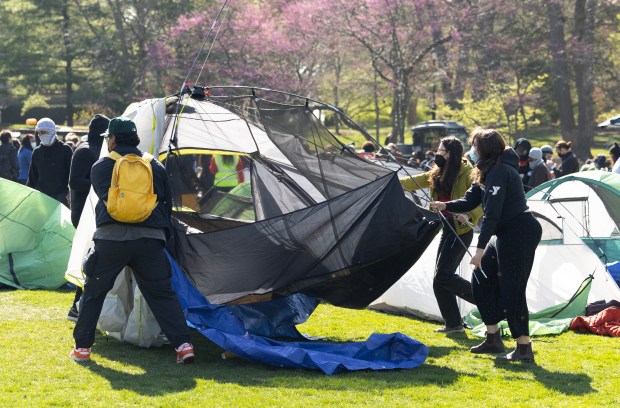 Northwestern University students and community members drag a tent into the encampment on campus in Deering Meadow on April 25, 2024, in Evanston. (Stacey Wescott/Chicago Tribune)