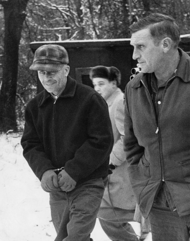 Ed Gein is led away by Sheriff Arthur Schley near Plainfield, Wisconsin, in 1957 after he admitted to murdering two women and robbing graves. (John Croft/Minneapolis Tribune) 