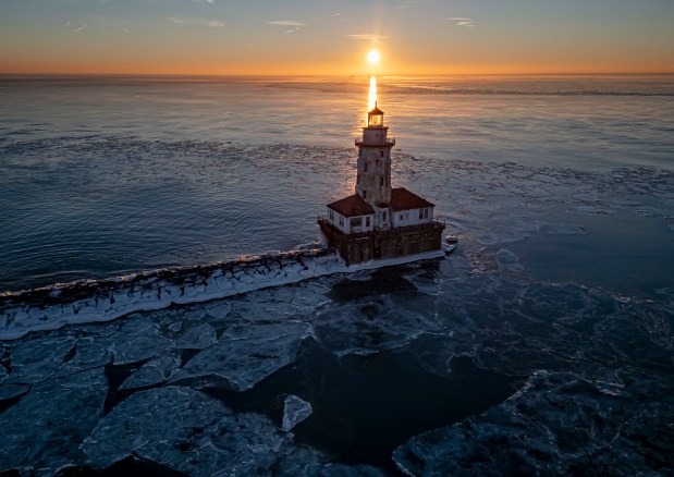 Ice forms around the Chicago Harbor Lighthouse on Lake Michigan after sunrise after a week with temperatures around zero on Sunday, Jan. 21, 2024. (Brian Cassella/Chicago Tribune)