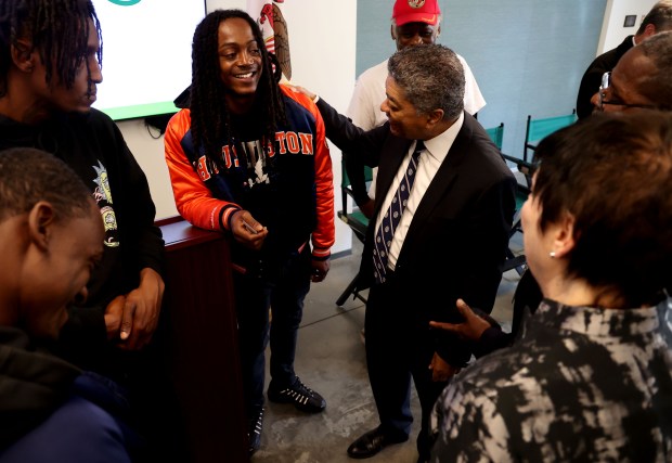 Chief Judge Timothy C. Evans, right, speaks with graduate Jurrell Davis, center, along with graduates family members following the North Lawndale Restorative Justice Community Court graduation ceremony at UCAN Chicago on Oct. 13, 2022. (Antonio Perez/ Chicago Tribune)