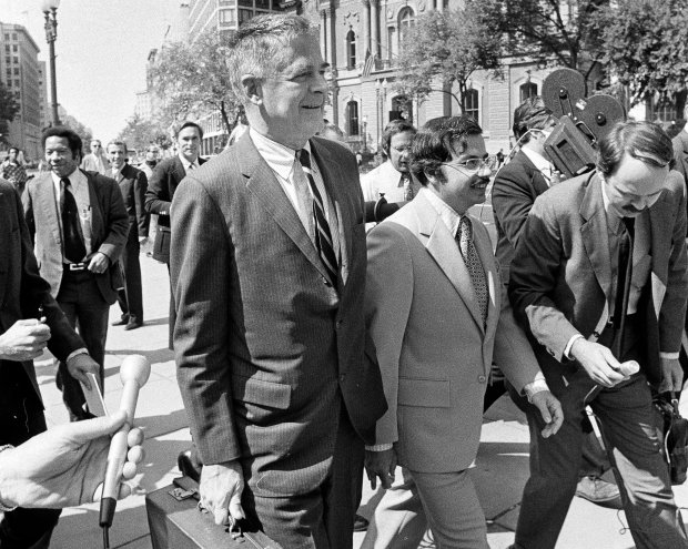 Special Watergate prosecutor Archibald Cox, left, and Philip A. Lacovara, one of his assistants, walk between newsmen in Washington, Sept. 20, 1973, following the meeting in the Executive Office Building with President Nixon's attorneys. The meeting was held in an effort to settle out of court the battle over presidential tapes related to the Watergate affair. (John Duricka/AP)