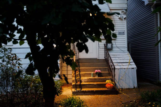 Flowers, a candle and old police tape are outside the home in the 5900 block of North Washtenaw Avenue on Oct. 12, 2022, where Frances Walker was found dead inside the residential building. (Armando L. Sanchez/Chicago Tribune)