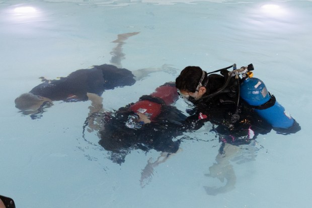 Erin Tunison, center, participates in a scuba diving class with Jim Elliott and Tinamarie Hernandez of Dive Heart, a non profit that helps people with disabilities learn to scuba dive in Downers Grove on Monday, April 1, 2024. (Troy Stolt/for the Lake County News Sun)