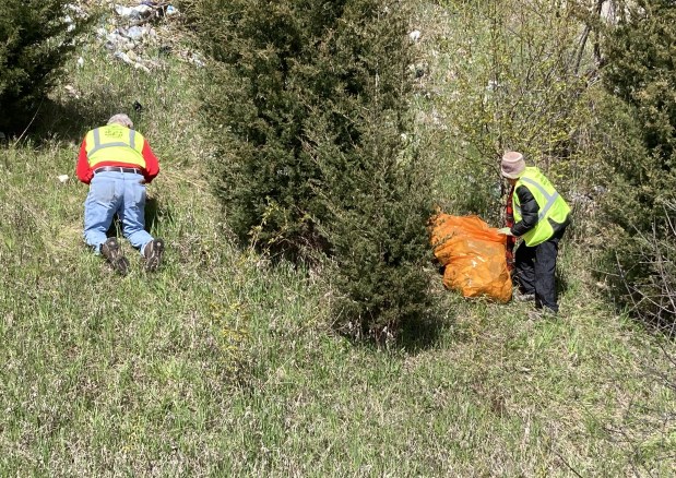 Marty Wozniak, left, and Patricia Hogan work their way up the bluff on the west side of the Amstutz Expressway while clearing it of trash. (Steve Sadin/Lake County News-Sun)