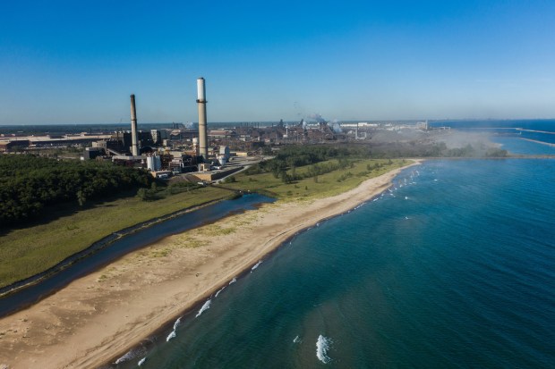 The ArcelorMittal steel mill (now owned by Cleveland-Cliffs) and permanently closed Bailly Generating plant, left, in Burns Harbor is seen from Indiana Dunes National Park in 2019.