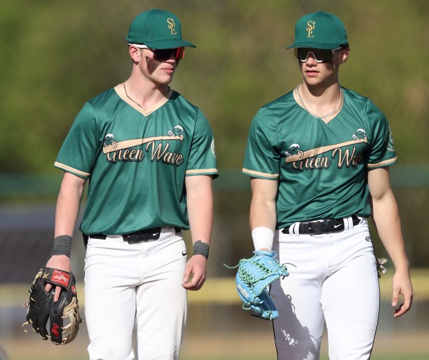 St. Edward's Jack Cozzi (9), left, and Joseph DuSell (7) walk to the dugout after warmups before a Chicagoland Christian Conference game against Marian Central on Wednesday, May 1, 2024 at Wing Park in ElginH. Rick Bamman / For the Beacon News