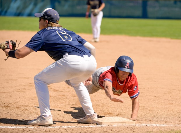 West Aurora's Emilio Ayala (8) dives safely back to first beating the throw to Neuqua Valley's William Zalabak (6) during the Class 4A Neuqua Valley Regional final in Naperville on Saturday, May 25, 2024. (Mark Black / for the Beacon-News)