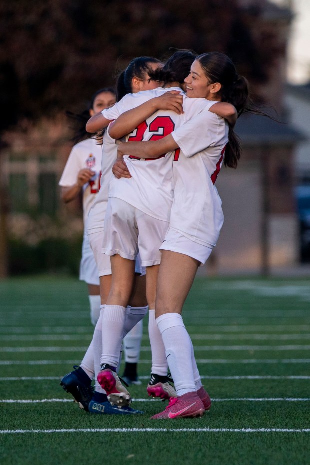 The East Aurora Tomcats embrace Nicole Olivo (22) after scoring their first goal during a game against Fenton High School in Bensenville on Tuesday, May 7, 2024. (Nate Swanson/for the Beacon News)