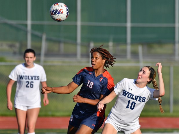 Oswego East's Morgan Dick (10) struggles for position with Oswego's Jordyn Washington (18) as the ball arrives during their Class 3A Lockport Regional semifinal game on Wednesday, May 15, 2024, in Lockport.(Jon Cunningham/for The Beacon-News)