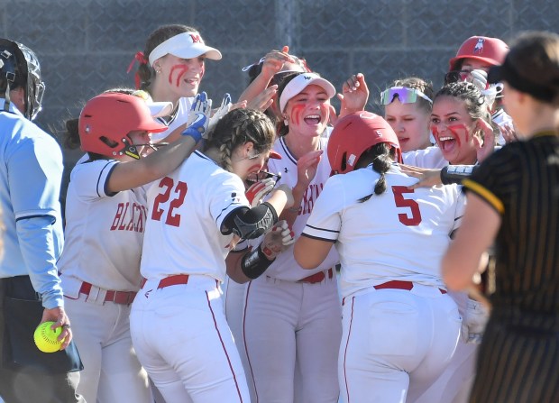 West Aurora's Diana Vargas (5) is mobbed by her teammates as she arrives at home plate after hitting a two run home run against Metea Valley during a Class 4A Metea Valley Regional semifinal game on Wednesday, May 22, 2024, in Aurora.(Jon Cunningham/for The Beacon-News)