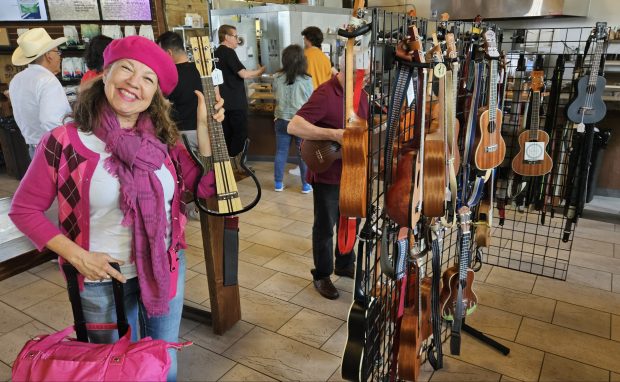 Victoria Lopez of Chicago, who admits she already owns 10 ukuleles, was looking to buy more Sunday at the Two Brothers Roundhouse in Aurora where the seventh Aurora Ukulele Fest was held. (David Sharos / For The Beacon-News)