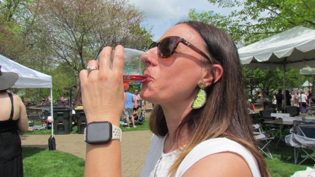 Lexie Brown tastes some wine at the Wine on the Fox festival in Oswego on Saturday. She came with a group of eight friends from the Joliet area to enjoy the fest, which ran Saturday and Sunday at Hudson Crossing Park. (Linda Girardi / For The Beacon-News)