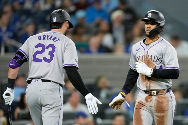 Colorado Rockies' Ezequiel Tovar (14), right, is congratulated by teammate Kris Bryant (23) during the third-inning of a baseball game against the Toronto Blue Jays in Toronto, Friday, April 12, 2024. (Frank Gunn/The Canadian Press via AP)
