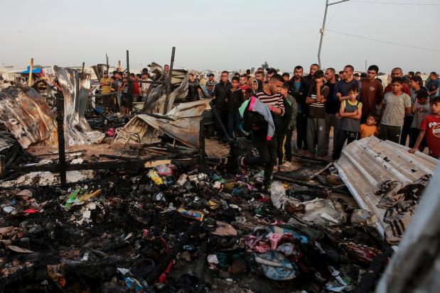 Palestinians look at the destruction after an Israeli strike where displaced people were staying in Rafah, Gaza Strip, Monday, May 27, 2024. Palestinian health workers said Israeli airstrikes killed at least 35 people in the area. Israel's army confirmed Sunday's strike and said it hit a Hamas installation and killed two senior Hamas fighters. (AP Photo/Jehad Alshrafi)