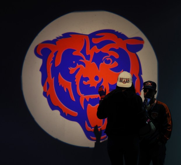 Fans take pictures in front of an illuminated Bears logo during the draft watch party at Soldier Field on April 25, 2024. (John J. Kim/Chicago Tribune)