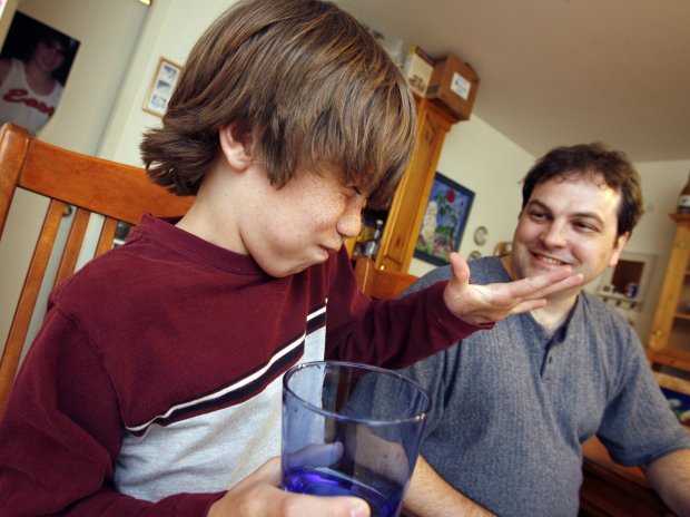 Andrew Moore, of Warrenville, tastes cicadas that his dad, Kirk, battered and fried on May 25, 2007. (Antonio Perez/Chicago Tribune)