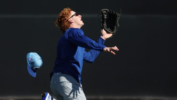 Cubs outfielder Owen Caissie loses his hat as he chases down a fly ball on Feb. 22, 2024, at Sloan Park in Mesa, Ariz. (Stacey Wescott/Chicago Tribune)