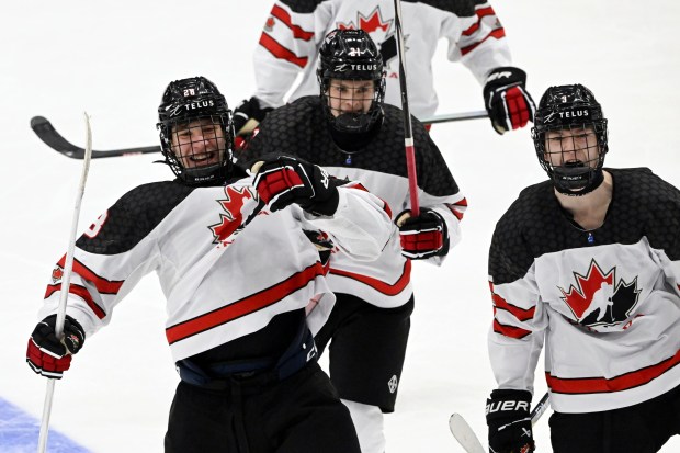 Goal scorer Cole Beaudoin, from left, Ryder Ritchie and Matthew Schaefer of Canada celebrate a power-play goal during the IIHF U18 World Championship final on May 5, 2024, in Espoo, Finland. (Jussi Nukari/Lehtikuva via AP)