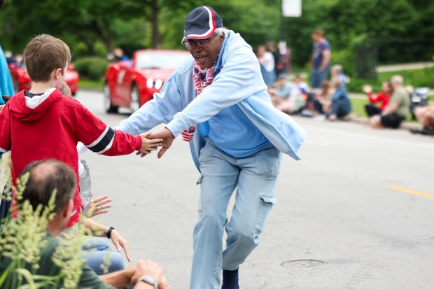 A member of the National Women Veterans United high-fives people watching the Beverly/Morgan Park Memorial Day parade on May 27, 2024. (Eileen T. Meslar/Chicago Tribune)
