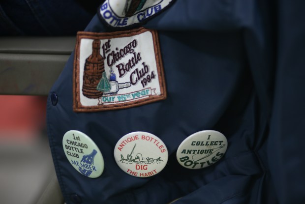 Frank Bradbury's jacket shows off patches and buttons during a monthly meeting of the 1st Chicago Bottle Club in Hinsdale on April 19, 2024. The club is an antique bottle collecting club that's been around since the 1970s. (Trent Sprague/for the Chicago Tribune)