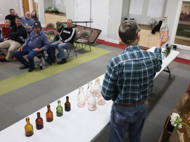 Craig Wright, of Western Springs, describes bottles in his collection to fellow members during a monthly meeting of the 1st Chicago Bottle Club on April 19, 2024. (Trent Sprague/for the Chicago Tribune)