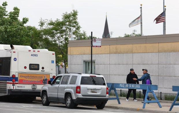 People walk outside of Chicago's landing zone for migrants on South DesPlaines Street at Polk Street on May 14, 2024. (Chris Sweda/Chicago Tribune)