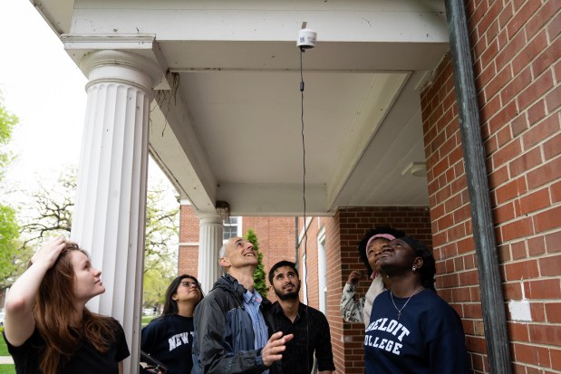 Beloit College professor Pablo Toral and students troubleshoot an air quality monitor they had placed on the school's campus, May 2, 2024. (E. Jason Wambsgans/Chicago Tribune)